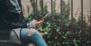 Person using smartphone in text-based therapy session